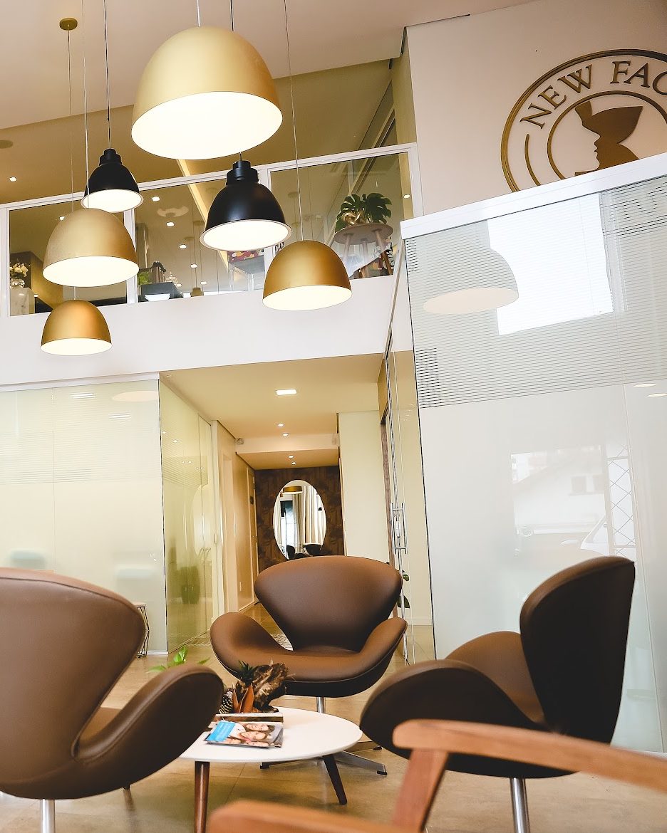 Sala de espera do New Face Institute em Joinville, com a marca do instituto na parede
